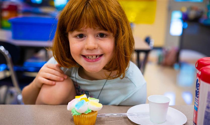 A girl with red hair smiles